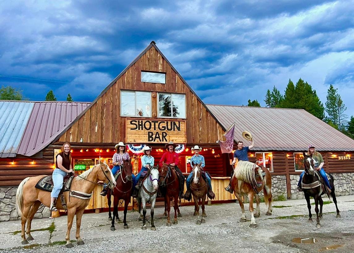 Locals on horseback outside of the Shotgun Bar in the Yellowstone Teton Territory.