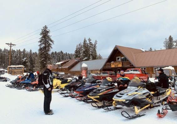 Snowmobiles outside of the Shotgun Bar in the Yellowstone Teton Territory, the perfect place to stop for dining and drinks after a long day in the cold. 